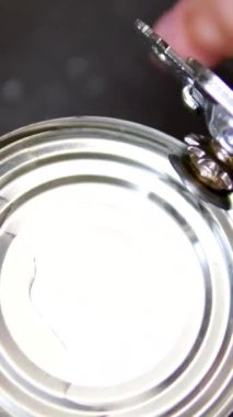 Konserve açacağı gri bir arka planda döner. Metal konserve açacağı. Yakın plan. Yüksek kalite 4k görüntü