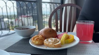 Kız kahvaltı etmek için masaya oturur çatal bıçak bacaklarını alır güzel, tanınmayan bir kadın kahvaltı için büfeye tabak getirir. Yüksek kalite 4k görüntü