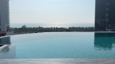 Bangkok şehir merkezindeki apartmanın çatısında yüzme havuzu, şehir manzarası. Tatil tatili konseptinde yaz sezonunda dinlenmek. Eğlence yaşam tarzı. 4k görüntü