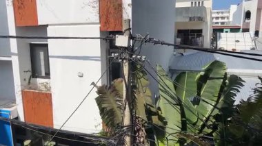 Parlak mavi gökyüzü küçük bir kasabadaki elektrik hatlarını ortaya çıkarıyor. Vietnam Şehri Danang direkleri ve telleri