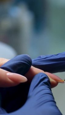 Tırnak cilası sürme, mor ötesi jöle, vernik, güzellik salonunda manikür süreci konsepti. Çalı üzerinde şeffaf palto damlası. Pembe arka planda. Tırnak cilası başvurusu. Yüksek kalite 4k