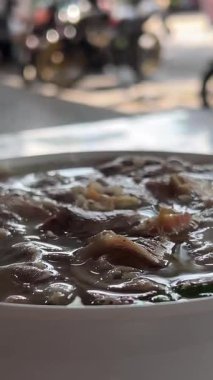 Erişte, göğüs eti, fasulye filizi, işkembe ve biberli buharlı Pho yemek tabağı. Tabağa kireç ekle