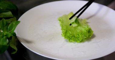 Mutfak konsepti, ev yapımı yemekler için hazırlama malzemeleri. Önlük giymiş, yemek pişiren genç bir kadın mutfak tezgahında sebzeli börek yapıyor. Ev yemeği ve gastronomi..