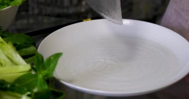 Mutfak konsepti, ev yapımı yemekler için hazırlama malzemeleri. Önlük giymiş, yemek pişiren genç bir kadın mutfak tezgahında sebzeli börek yapıyor. Ev yemeği ve gastronomi..