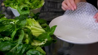 Mutfak konsepti, ev yapımı yemekler için hazırlama malzemeleri. Önlük giymiş, yemek pişiren genç bir kadın mutfak tezgahında sebzeli börek yapıyor. Ev yemeği ve gastronomi..