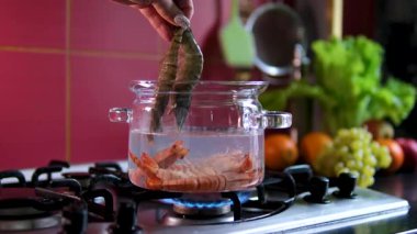 Gaz ocağında su kaynatmak ve yumurta haşlamak ve pişirmeden önce balığı kaynar suda kurutmak. Yüksek kalite 4k görüntü