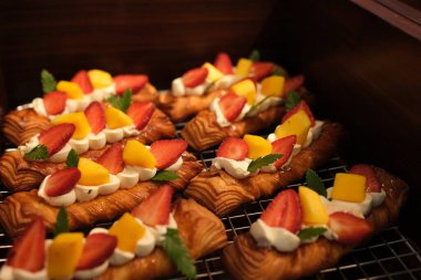 Vanilyalı pasta kremalı çilekli turtalar. Kurabiye kabuğunda kremalı vanilyalı kremayla dolu mini meyveli turtalar. Tahtada ev yapımı tatlı, dikey görüntü. Yüksek kalite fotoğraf