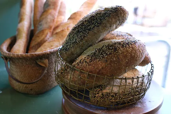 Tahta masanın üzerinde farklı türde taze ekmek olan bir sepet. Yüksek kalite fotoğraf