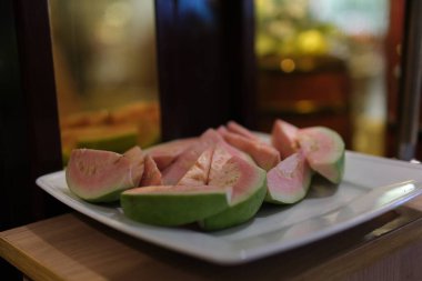 İzole edilmiş Guava, dilimlenmiş abd guava yapraklarıyla olgunlaşmış guava meyvesi. Yüksek kalite fotoğraf
