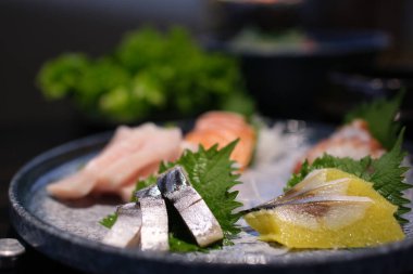 Taze kesilmiş çiğ balık, siyah arka planda suşi olarak servis edilir. Yüksek kalite fotoğraf