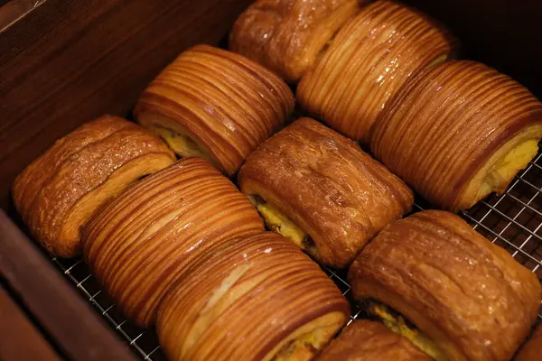 Doğal ışıkta tabakta altın katmanlı hamur işi, kabarık kenarlı ve tatlı kaplamalı, bu hamur işleri kahvaltı ya da tatlı için mükemmel bir köy cazibesini çağrıştırıyor. Yüksek kalite fotoğraf