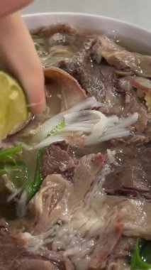 Sıcak bir kase Vietnam usulü tavuk çorbası, limonlu ve taze otlu. Yüksek kalite 4k görüntü