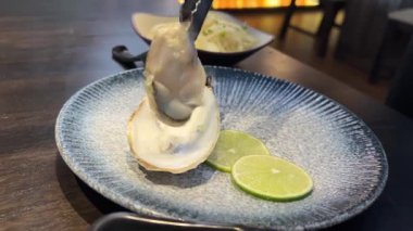 Peynirli, limonlu ve tabakta otlarla pişirilmiş istiridye. Sunum menüsü deniz ürünleri restoranı. Akdeniz mutfağı. Deniz ürünleri kompozisyon üst görünümü sunuyor. Sağlıklı beslenme 