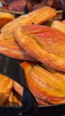 Elmalı turtalar, pastalar, bir fincan sıcak çay ve bir mum eşliğinde beyaz kağıtla kaplanmış dokunmuş bir sepetin içinde şeker kaplı bir yüzey. Yüksek kalite