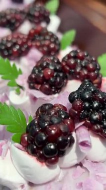 yuvarlak kruvasan, kremayla doldurulmuş ve üzeri yabanmersini ve çilekle kaplı altın kahverengi hamur işi. uzun beyaz krema ve şeker kaplı tatlı. Yüksek kalite