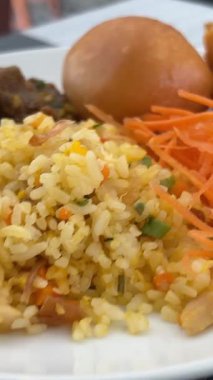 Restoran masasında bir tabak kızarmış pirinç ve karides, hareket manzaralı. Taze havuç ve çırpılmış yumurta.