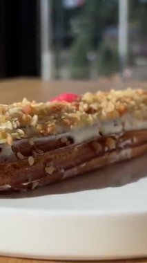 Kremalı pasta ekini. Beyaz tabaktan ekini alıyor. Kadınların ellerinin tutulmasıyla yakınlaş. Kadınlar, beyaz tabaktan çikolata kremalı, yakın planda jöleli tatlı seçiyorlar. 4k 