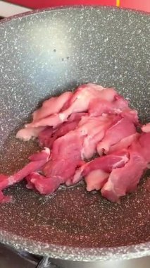 Bir şef mutfaktaki bir tavada biftek pişirir ve onu diğer tarafa çevirir, yakın plan yemek. Lezzetli biftek yapma süreci. Yüksek kalite 4k görüntü