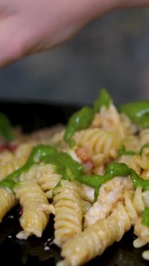 Zengin domates sosu ve ahşap bir masada taze fesleğen yapraklarıyla süslenmiş fesleğenli makarna. Yüksek kalite 4k görüntü