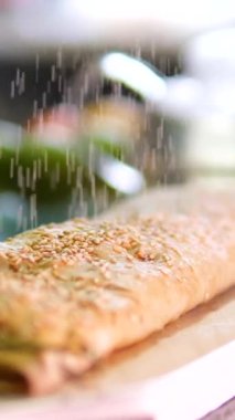 süzme peynirli, peynirli ve dutlu gözlemeler. Tereyağlı karamelli sos içinde elma ve kuru üzümle dolu ince Fransız krepi. Tüpün içinde. Pudra şekeri serpin. Yüksek kalite 4k