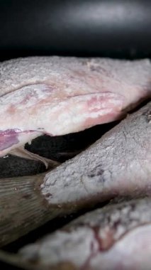 Ev yemeği. Kızartma tavasında ayçiçeği yağıyla sazan balığı kızartan bir kadın. Yüksek kalite 4k görüntü