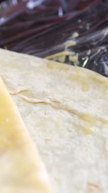 Donör hazırlama, mutfak önlüğü giymiş yumurta gibi genç bir kadınla fırçalama, dilimlenmiş salatalık, lahana ve tavukla pide ekmeği sarma süreci. Yüksek kalite 4k görüntü