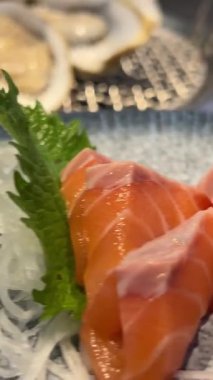 Japon restoranında saşimi yiyen Asyalı genç bir kadın. Yüksek kalite 4k görüntü