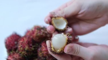 Kıllıyı çıkarmak için kolay bir yöntem. Bir egzotiğin kırmızı kabuğu. Tropik rambutan meyvesi. Güneydoğu Asya 'da tatlı bir lezzet. 4K görüntü 2160p. Yüksek kalite 4k görüntü