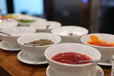 Gri arka planda farklı soslar ve malzemelerle dolu kaseler. Mesaj için yer var. Yüksek kalite fotoğraf