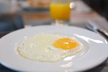 Geleneksel kahvaltı yemekleri arasında yumurta suyu tabağı İngiliz kahvaltısı yumurta, portakal suyu var. Sıcak ve davetkar kahvaltı sahnesi, yemek temaları için mükemmel, lezzetli kahvaltıların altını çiziyorum. 