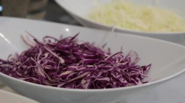 Tahta kesme tahtasının üzerinde kırmızı lahana dilimlenmiş.