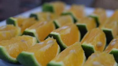 Bir tabakta dilimlenmiş portakal dilimleri. Sulu portakal. Vietnam Yeşil Çince Turuncu