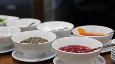 Gri arka planda farklı soslar ve malzemelerle dolu kaseler. Mesaj için yer var. Yüksek kalite fotoğraf