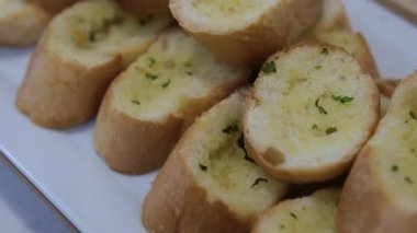 Beyaz seramik tabakta taze maydanozlu üç dilim sarımsaklı ekmek. Üst Manzara. Yüksek kalite fotoğraf