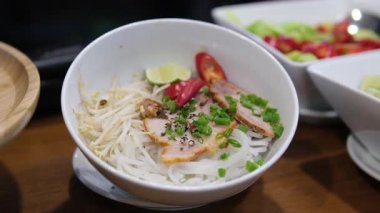 Geleneksel Vietnamca otlar, et, Pirinç Noodle Pho bo çorba suyu. Pho bo chopsticks, kase kaşık. Metin için yer. Üstten Görünüm. Ahşap masa arka plan Asya yemek Pho bo. Vietnamca çorbası