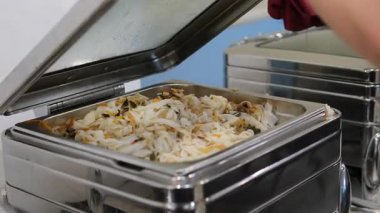 Lezzetli bir yemek sahnesi açık büfe sırasında erişteyle servis edilen bir tabağı sergiliyor. Yüksek kalite 4k görüntü