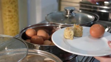 Taze kaynamış yumurtalarla dolu beyaz bir tabağı kapatın, açık büfeye koyun, temiz ve iştah açıcı bir görsel yaratın.