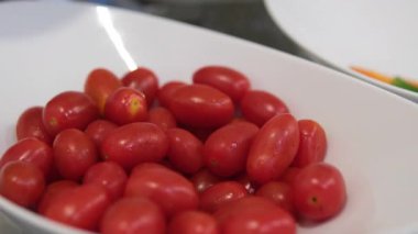 Kırmızı kiraz domatesleri bir kutunun içinde yatıyor.