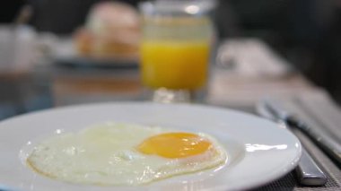 Geleneksel kahvaltı yemekleri arasında yumurta suyu tabağı İngiliz kahvaltısı yumurta, portakal suyu var. Sıcak ve davetkar kahvaltı sahnesi, yemek temaları için mükemmel, lezzetli kahvaltıların altını çiziyorum. 