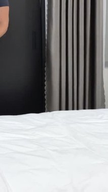 Yetişkin, yorgun, bavullu bir kadın gece geç saatte otele geldi. Bavulunu otele bıraktı. Yatağa bavul attı. Yüksek kalite 4k görüntü
