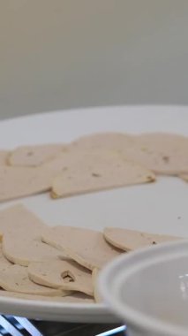 Fransız ekmeğiyle dilimlenmiş domuz pastırması. Sosis retro-stil yemek tepsisinde ve yemek kağıdında. Yavaş çekim kaydırağın üzerinde. Taze marul yaprakları da kullanıyoruz.