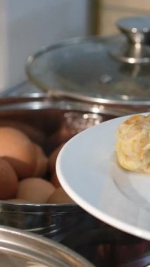 Taze kaynamış yumurtalarla dolu beyaz bir tabağı kapatın, açık büfeye koyun, temiz ve iştah açıcı bir görsel yaratın.