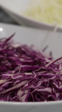 Tahta kesme tahtasının üzerinde kırmızı lahana dilimlenmiş.