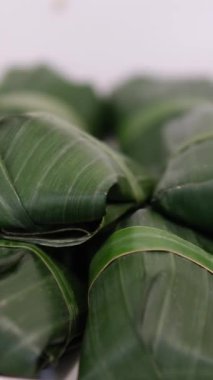 Muz yapraklarına sarılı taze yengeçler, yerel bir pazarda satışta sergileniyor, geleneksel deniz ürünleri hazırlıklarını vurguluyorlar..