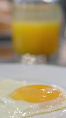 Geleneksel kahvaltı yemekleri arasında yumurta suyu tabağı İngiliz kahvaltısı yumurta, portakal suyu var. Sıcak ve davetkar kahvaltı sahnesi, yemek temaları için mükemmel, lezzetli kahvaltıların altını çiziyorum. 