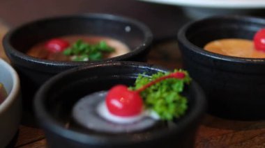 Renkli pastalarla dolu bir arka plan ve taze meyveli tatlılar. Kirazla süslenmiş kekler.