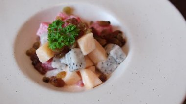 Meyve salatası, kavun, karpuz, beyaz, değerli meyve ve yoğurtla kaplı kuru üzüm. beyaz kalın tabak