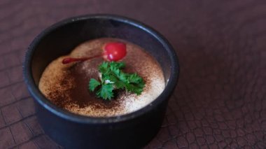 Taze naneli ev yapımı tiramisu keki. Beyaz mermer arka planda pembe tabakta tiramisu bölümü. Lezzetli, fırında tiramisu yok. Ev yapımı Highland Tiramisu Kremi