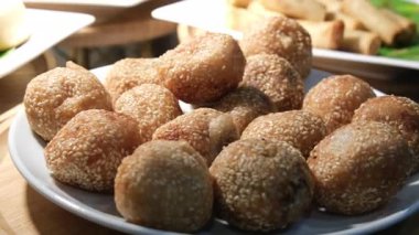 Lokma 'nın yavaş çekimde pembe tabağa düşen Türk usulü kızarmış çöreklerinin yakın çekimi. Ramazan. Yüksek kalite 4k görüntü