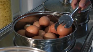 Bir düzine yumurta kaynayan bir tencerede zarif bir şekilde kaynatılır. Kabaran su her yumurtayı nazikçe sarıp mükemmel pişmiş mücevherlere dönüştürür. Yumurtalarının sarısı açılmayı bekler. Yüksek kalite 4k görüntü